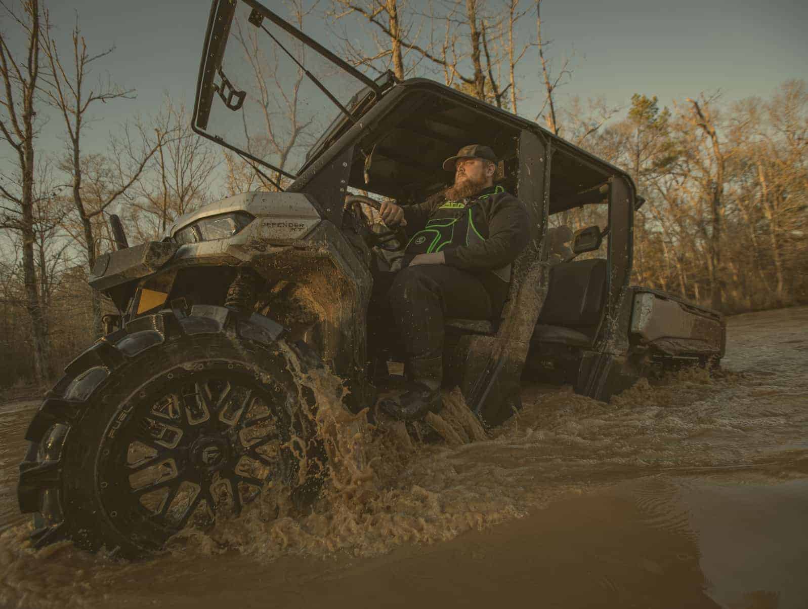 man in waders driving ATV